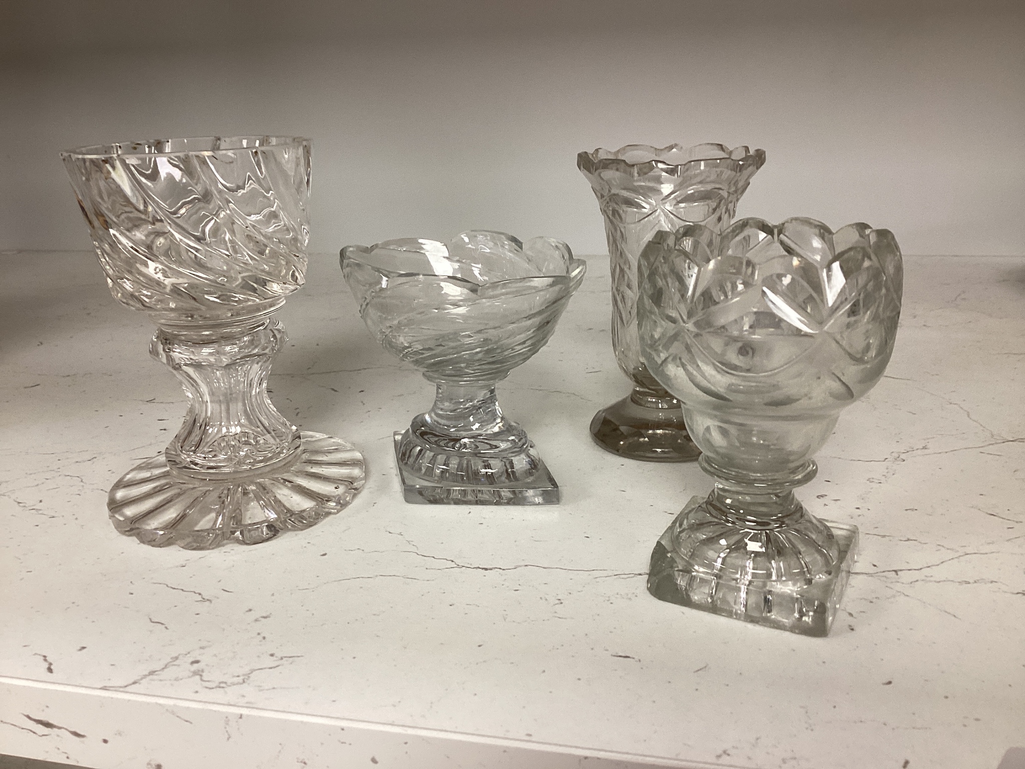 A set of twelve Victorian square base cut glass salts and four other 19th century clear glass salts.